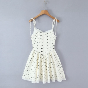Detail of French style polka dot dress featuring lace trim and adjustable tie straps