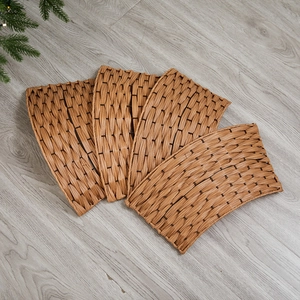 Base decorativa per albero di Natale in vimini marrone su pavimento in legno grigio
