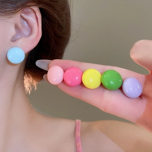 Detail view of colorful candy ball stud earring set with glossy resin finish on model