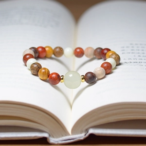 Close-up of heart-shaped prayer beads on a book with glowing beads and lion carving