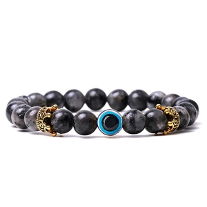 Detailed shot of turquoise evil eye bracelet with grey beads and golden crown charms