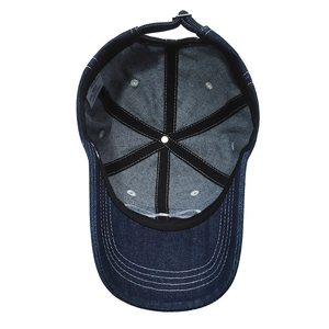 Internal view of washed denim baseball cap featuring six-panel stitching and a white label