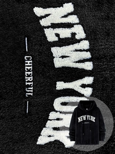 Detailed view of black sherpa fleece hoodie with white New York towel embroidery