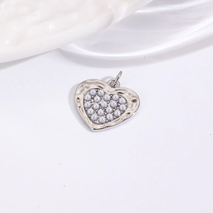 Macro shot of a silver-tone heart pendant featuring embedded faux white pearls