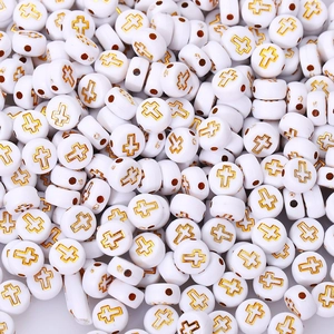 Macro view of white acrylic round beads with golden cross patterns for DIY jewelry making