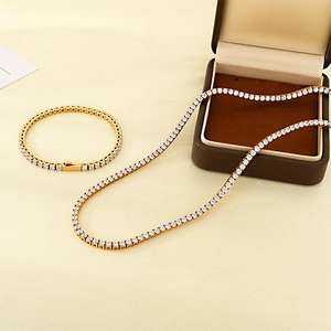 Détail d'un ensemble collier et bracelet tennis dorés avec zircons dans un coffret