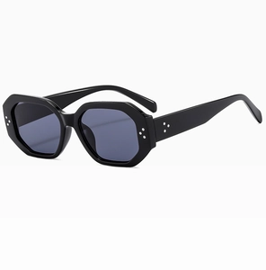Detail of polygonal black sunglasses featuring high-quality silver rivet accents