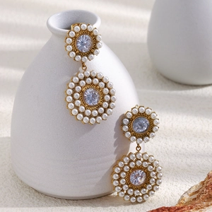 Detail of luxury 18K gold plated earrings with vintage pearls and round cubic zirconia