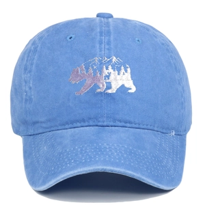 Primer plano de gorra de béisbol de algodón lavado azul con bordado de oso forestal.