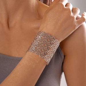 Vista dettagliata del bracciale a polsino argento con intagli floreali sul polso