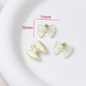 Detail view of 17mm x 15mm resin bow pendant with gold heart for DIY jewelry