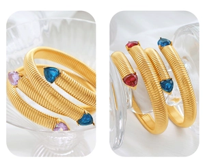 Detailed macro view of golden snake spiral bracelet with colorful heart-shaped gemstones