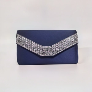 Close-up of navy blue satin evening clutch with sparkling V-shaped rhinestone details