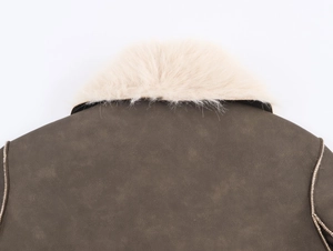 Detail of faux fur collar and textured brown leather on a reversible winter coat