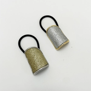 Detail of glitter ponytail cuffs in gold and silver finishes with black elastic bands