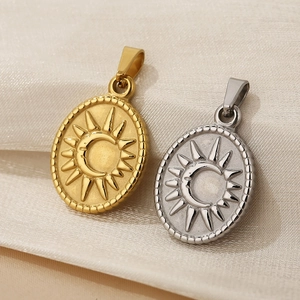 Macro detail of sun and moon embossed oval pendants on elegant beige satin fabric