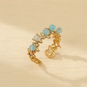 Detail view of gold star ring with light blue beads featuring 2.1cm inner diameter