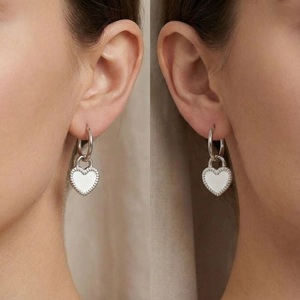 Close-up of a silver heart-shaped padlock charm on a stainless steel hoop earring