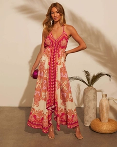 Detail of bohemian floral print on a long V-neck backless dress with warm indoor lighting