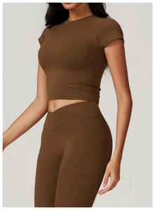 Detail of high-waist yoga leggings with V-cross waistband and matching crop top in dark brown