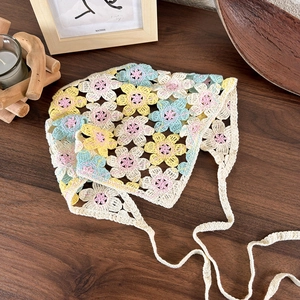 Detailed close-up of handmade crochet floral headscarf with macaron colored flowers