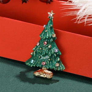 Christmas tree brooch with green enamel and colorful rhinestones on festive background
