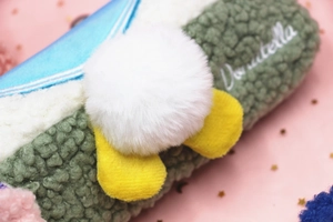 Detailed view of plush pencil case with Donutella embroidery and soft lamb wool texture