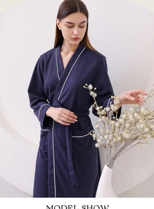 Detail of dark blue waffle robe featuring classic white piping and breathable texture