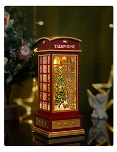 Close-up of a classic red British telephone booth music box with snowman and glowing lights