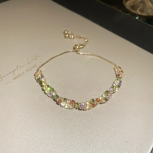 Close-up of adjustable gold bracelet featuring vibrant multi-colored zirconia stones
