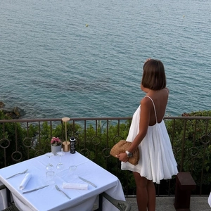 Elegante abito corto bianco con schiena scoperta e pieghe per vacanze estive