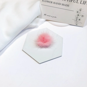 Macro shot of fluffy pink faux mink fur pompom accessory on marble display base