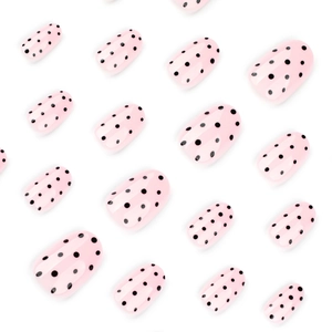Faux ongles courts ronds rose clair avec motif à pois noirs et finition brillante