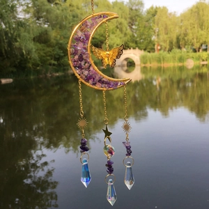 Detail of moon-shaped purple crystal suncatcher with gold butterfly and prisms