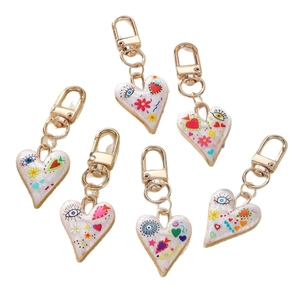 Colorful evil eye heart and flower charms with gold keychains on a clean white background