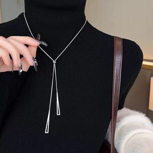 Elegant silver Y-shaped long necklace with double triangle pendants on black sweater