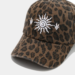 Détail de la casquette de baseball à imprimé léopard avec broderie soleil et texture coton