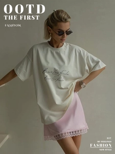 Detail of pink satin mini skirt featuring delicate lace hem and silky smooth texture