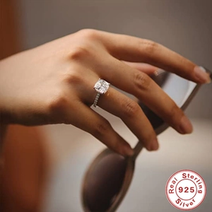 Macro shot of 925 sterling silver ring with square cut diamond on model's hand