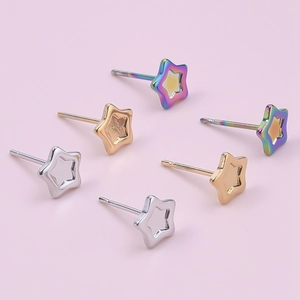 Macro detail of hollow star stud earrings in silver, gold, and rainbow stainless steel