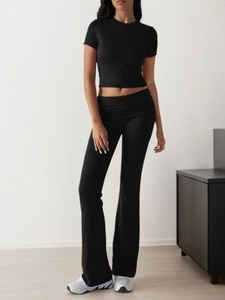 Women's black two-piece sports set with short sleeve crop top and high-waist flared pants