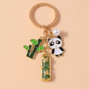 Detail of a golden keychain featuring cute panda, green bamboo leaf, and jade charms