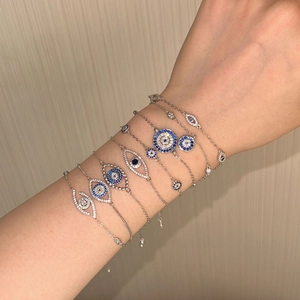 Nahaufnahme geschichteter S925 Silber Evil Eye Armbänder mit blauem Zirkon am Handgelenk