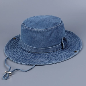 Detail of blue denim sun hat showing textured fabric, metal snap buttons and chin strap