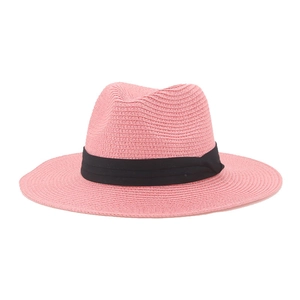 Detail of pink straw Panama hat with black ribbon band on a clean white background
