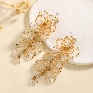 Detail of flower earrings featuring resin petals with small beaded gold tassels