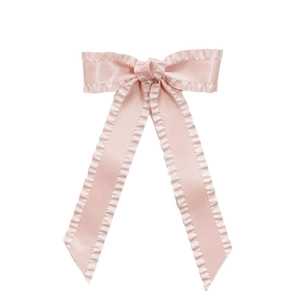 Elegant pink satin hair clip with ruffled edges and long ribbon in a centered flat lay view