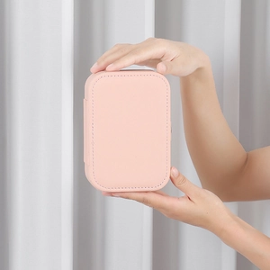 Portable pink PU leather jewelry organizer box held by hand for travel size scale