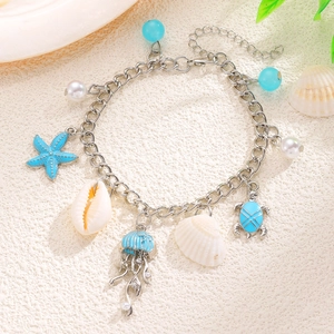Dettaglio della collana a tema marino con ciondoli a tartaruga blu, stella e medusa