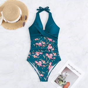 Detail of dark teal halter swimsuit with floral print and stylish holiday accessories